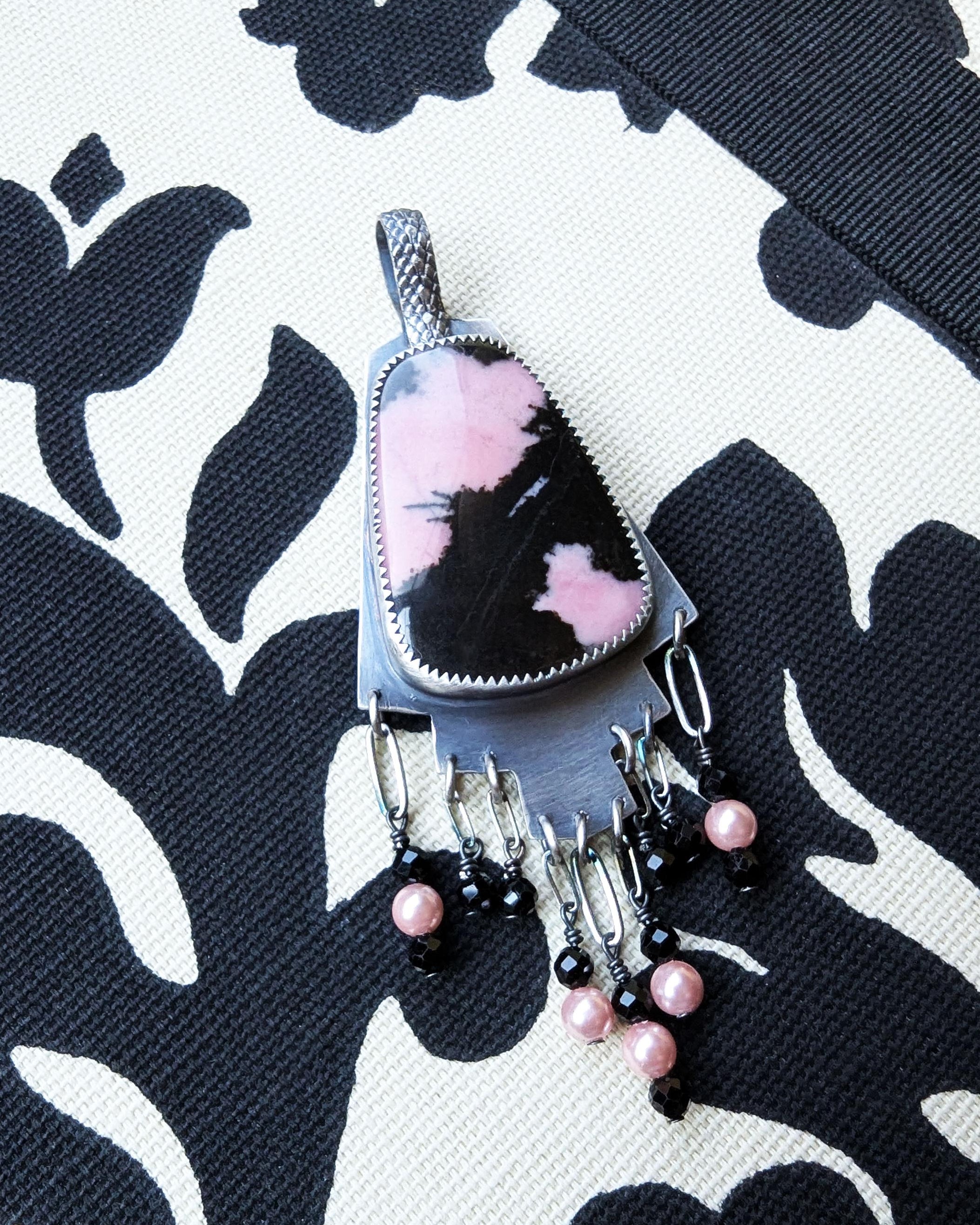 Hand-cut oxidized silver step design with symbolic pink stone