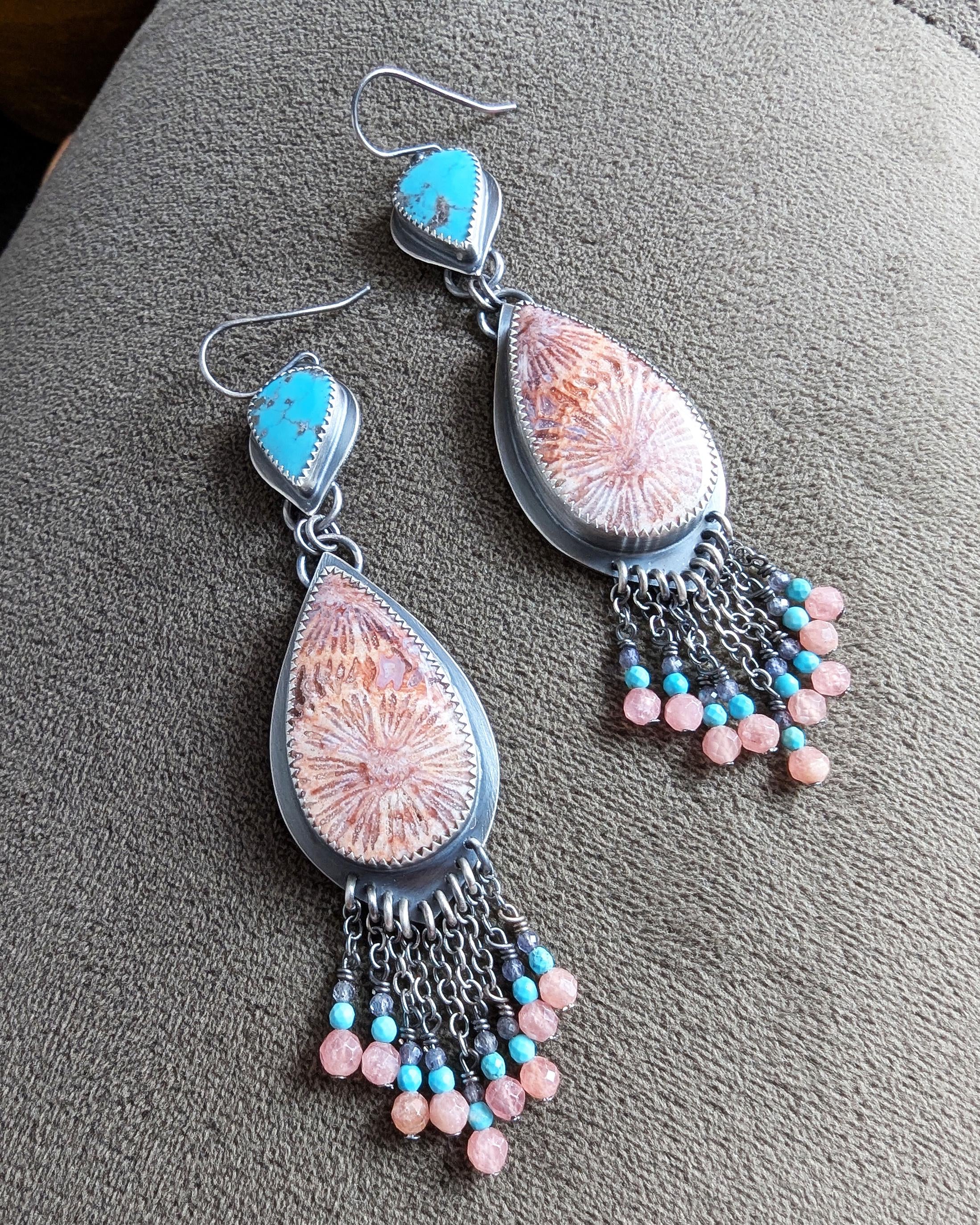 Close up of pear shaped turquoise earrings with fossil coral leaf dangles