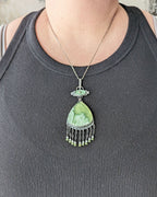 One of a kind green gemstone statement jewelry pendant by Rebellenhaus shown on bust for size