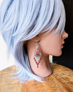 Kite-shaped oxidized sterling silver drops with jasper center on mannequin for scale