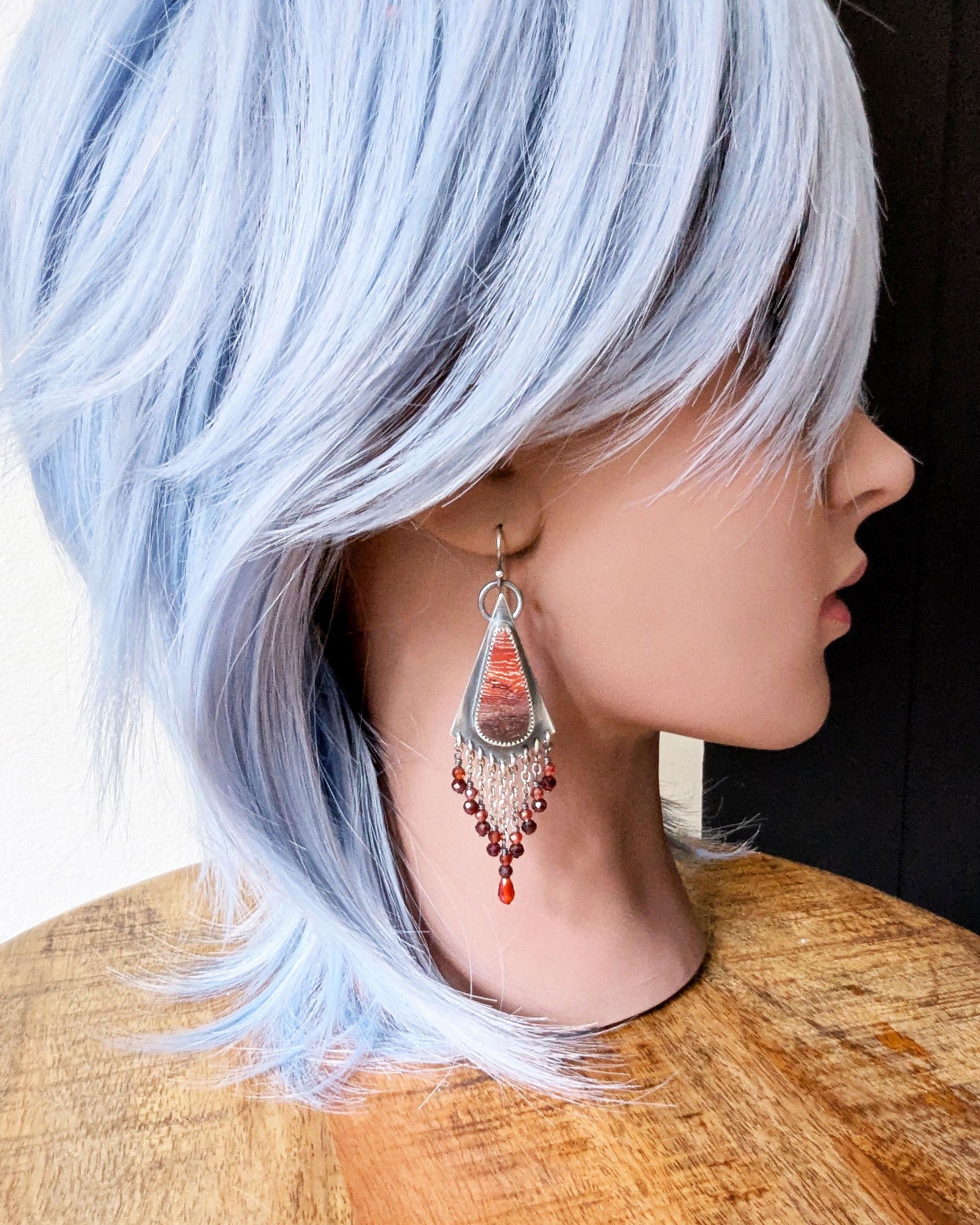 Kite-shaped oxidized sterling silver drops with jasper center on mannequin for scale