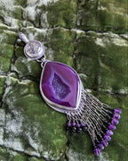 Close up of a regal two-stone pendant featuring druzy agate and black tourmaline with amethyst accents