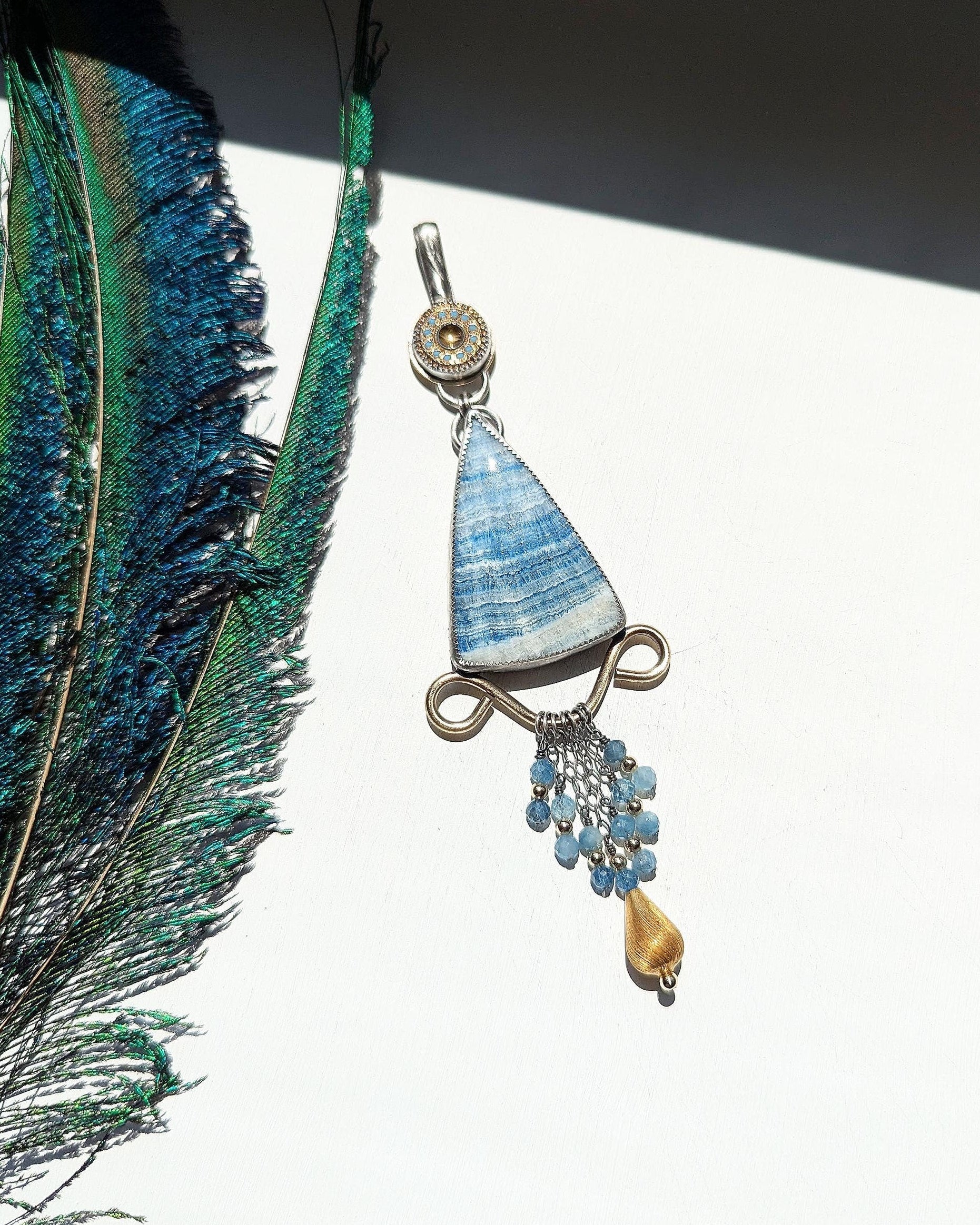 Triangular scheelite pendant with brass filigree detail