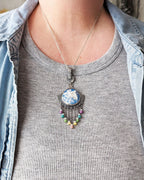 Artisan necklace with lavender, aqua, and pink gemstone accents on bust for scale
