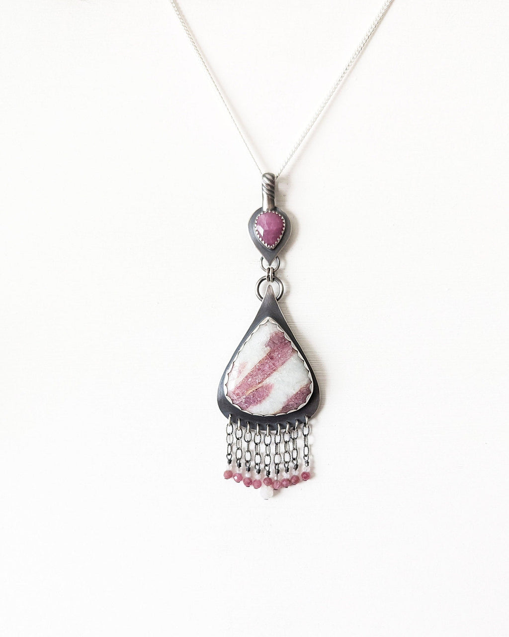 Close-up of rose cut pink sapphire set in oxidized sterling silver artisan pendant shown on chain (not included)