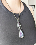 Moody violet artisan pendant with layered gemstone design on bust for scale