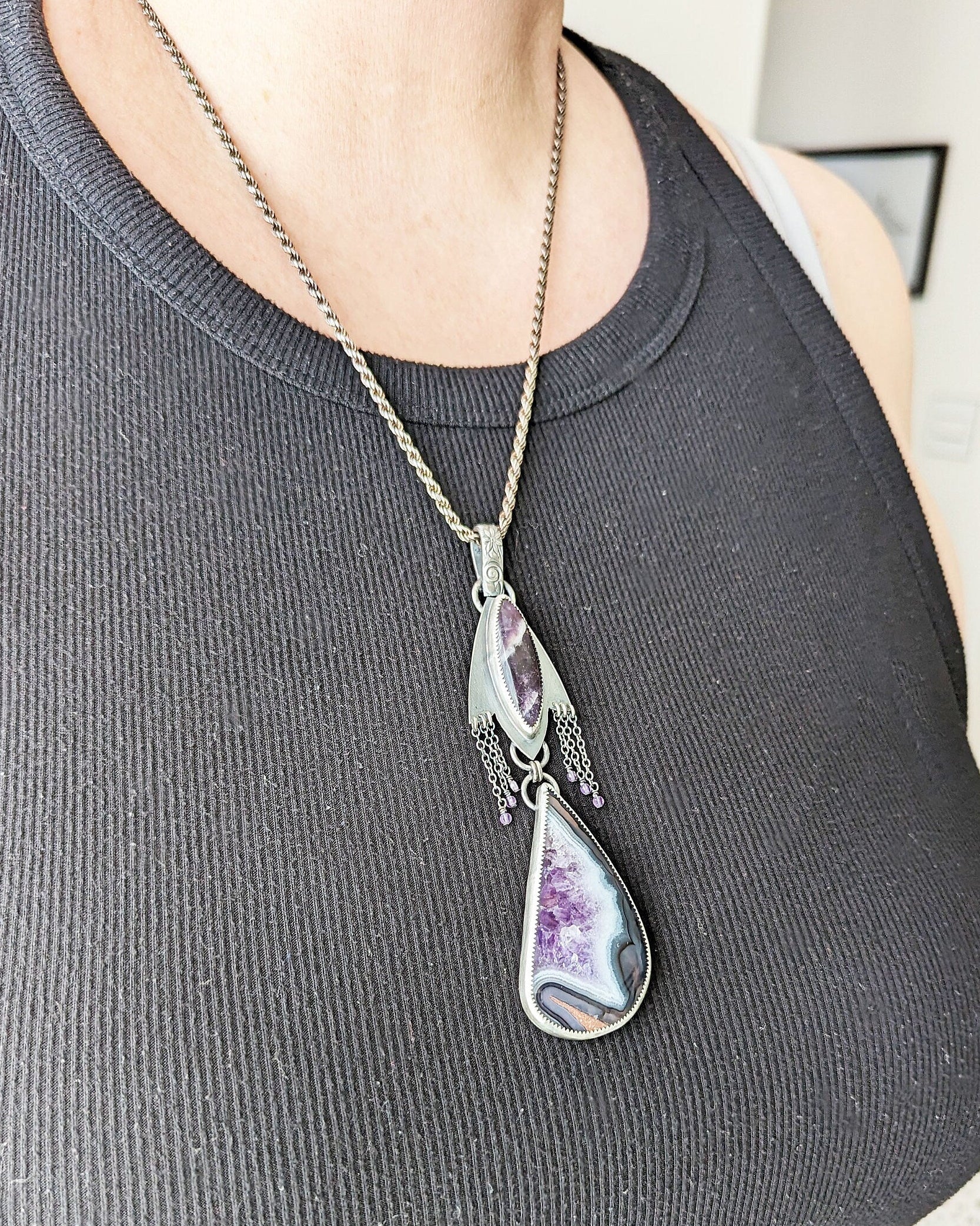 Moody violet artisan pendant with layered gemstone design on bust for scale