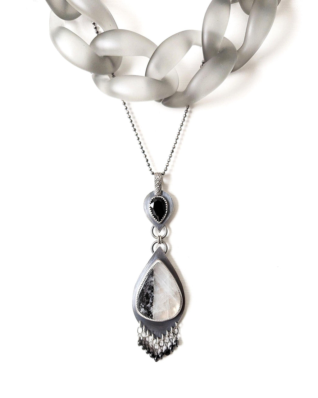 Video of Collector gemstone pendant featuring moonstone glow and onyx accent shown with layering necklace and on chain (not included)