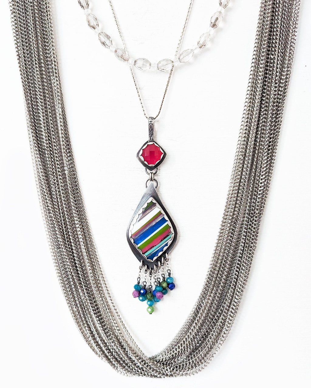 Pink chalcedony and surfite pendant necklace shown on chain with layer necklaces for style (not included)