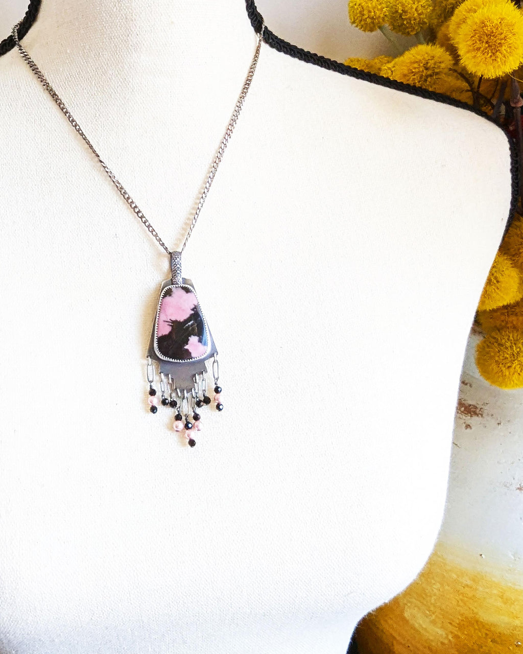 Hand-cut oxidized silver step design with symbolic pink stone