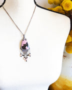 Hand-cut oxidized silver step design with symbolic pink stone