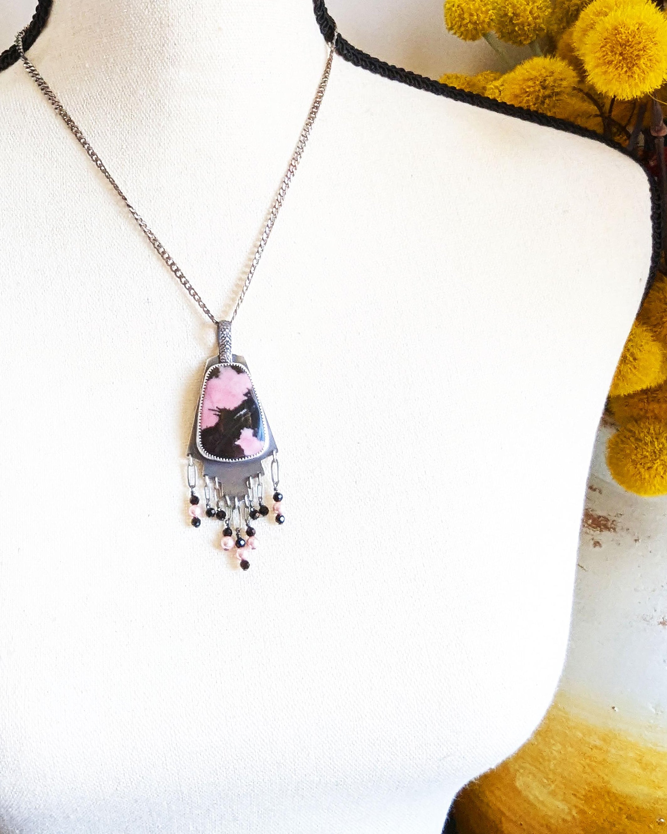 Hand-cut oxidized silver step design with symbolic pink stone