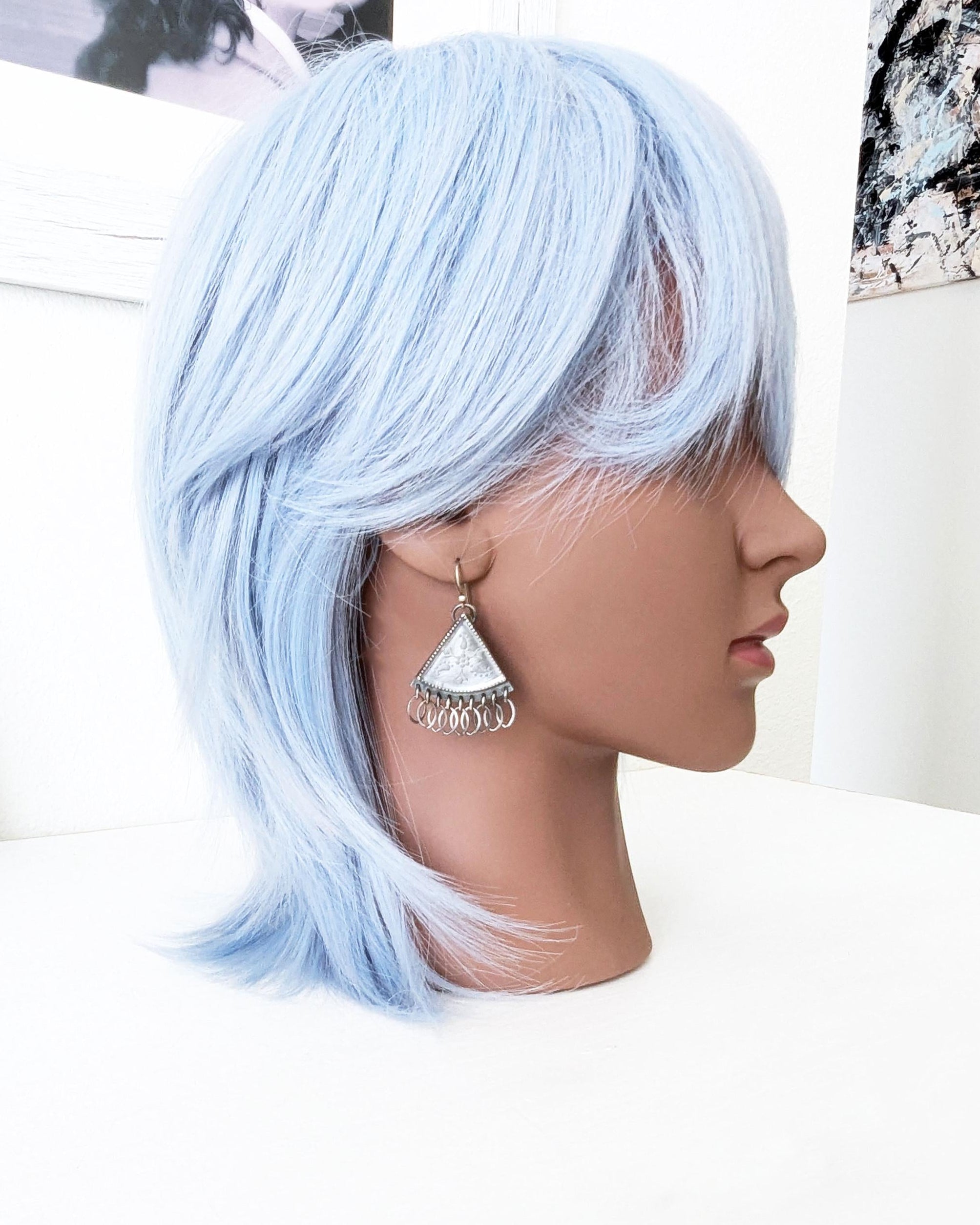 Handcrafted etched quartz triangle earrings worn for scale
