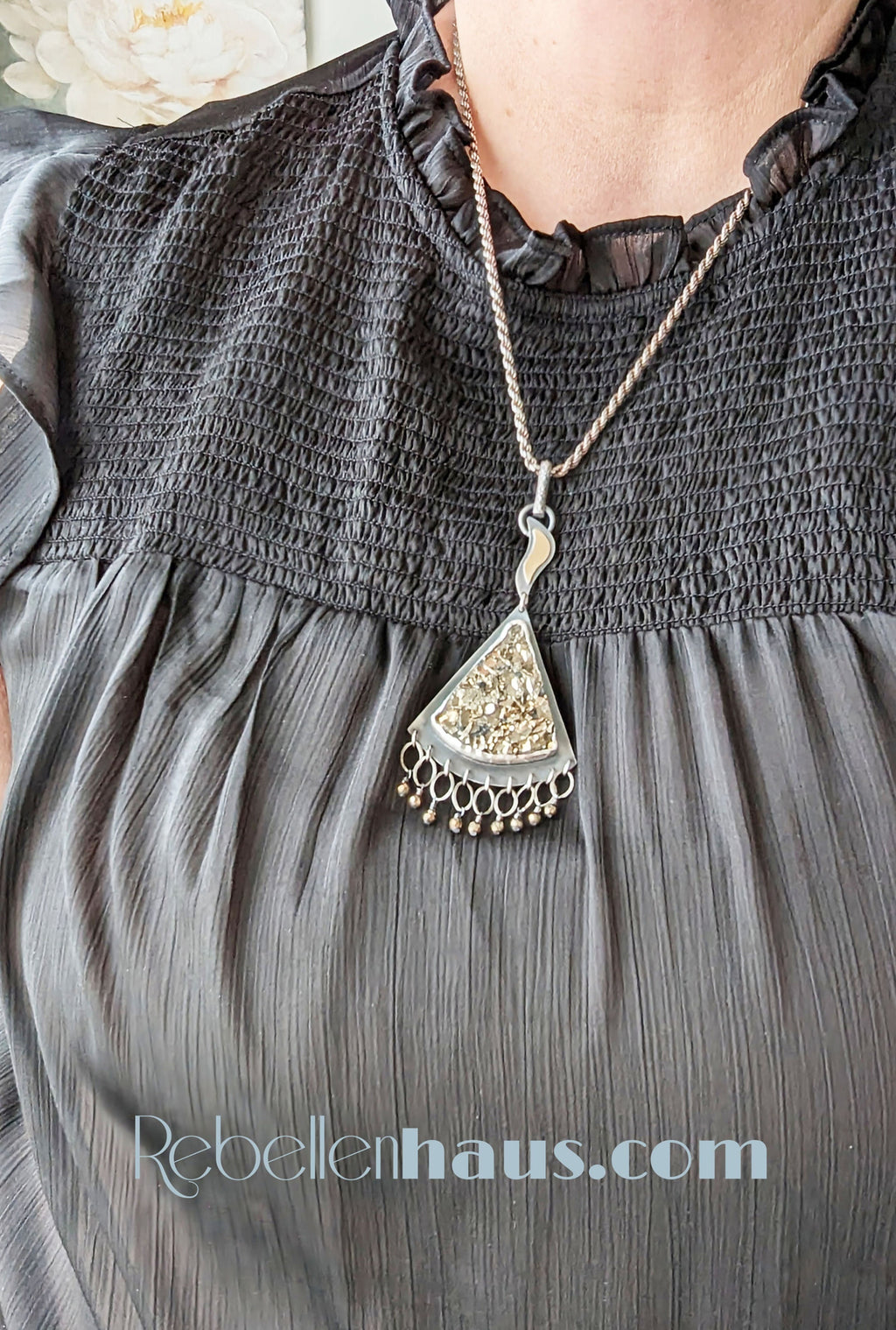 Triangular druzy pyrite pendant with flame-shaped handmade bail in oxidized silver shown on bust for size