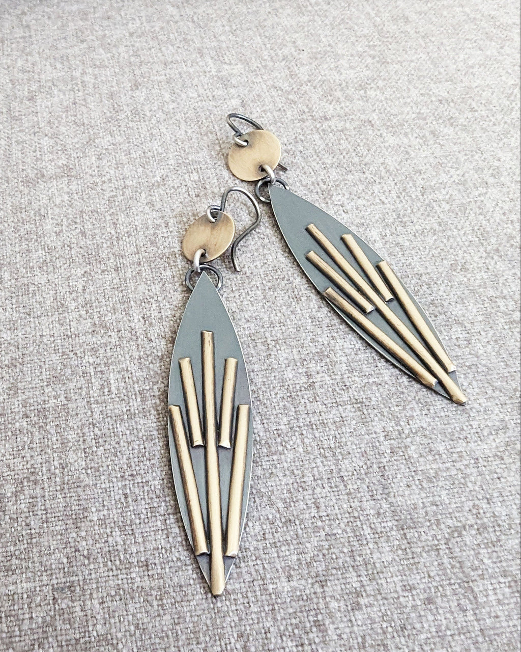 Pair of geometric earrings on a textured gray surface