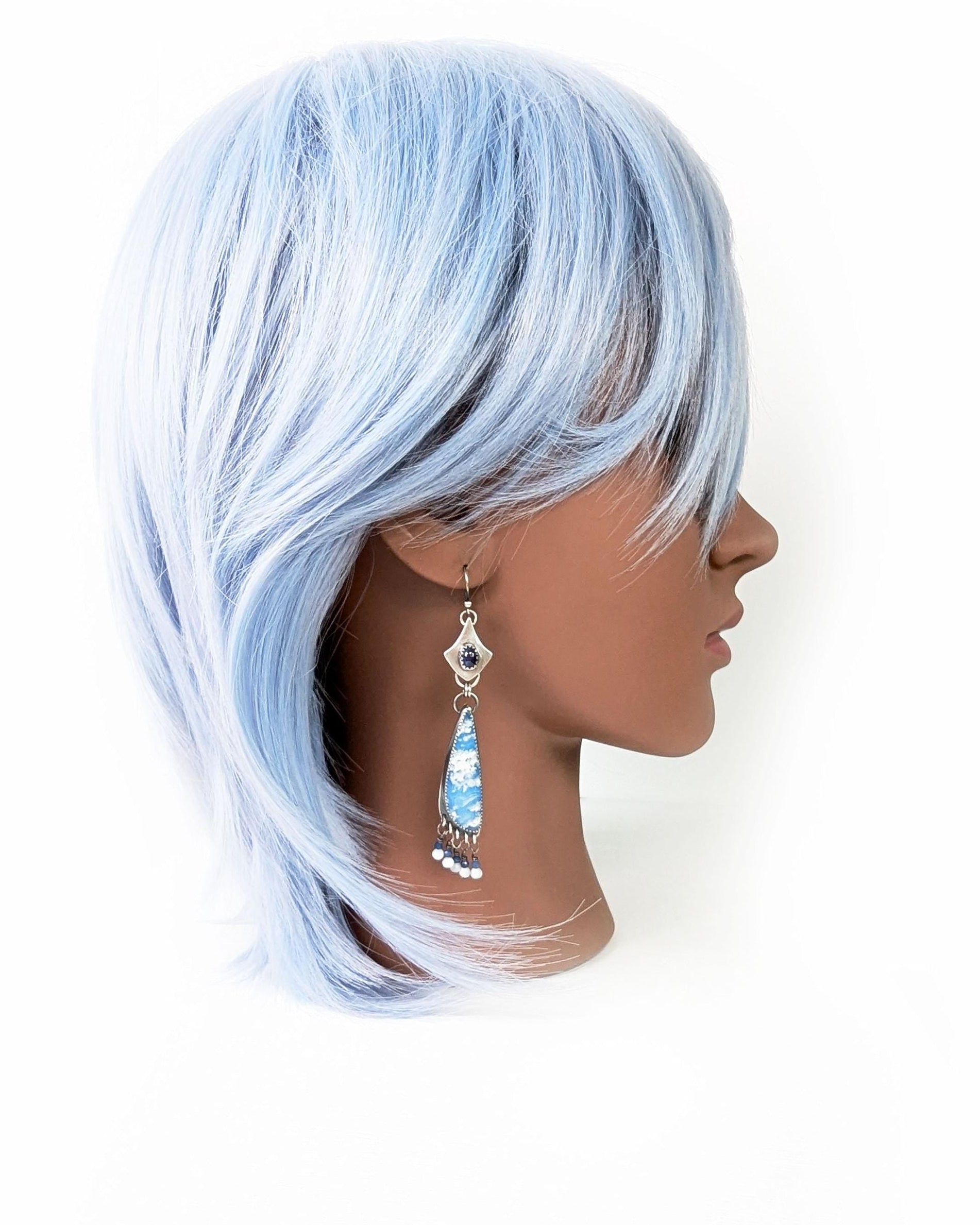 Handcrafted blue sapphire and plume agate earrings worn for scale on mannequin 
