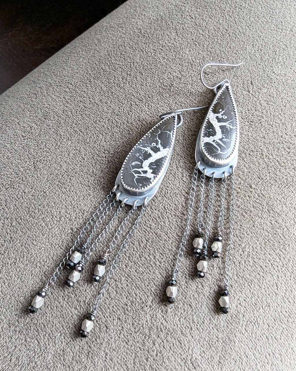 Bold earthy statement earrings with asymmetrical chain movement