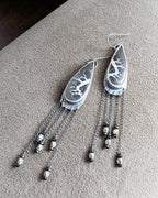Bold earthy statement earrings with asymmetrical chain movement