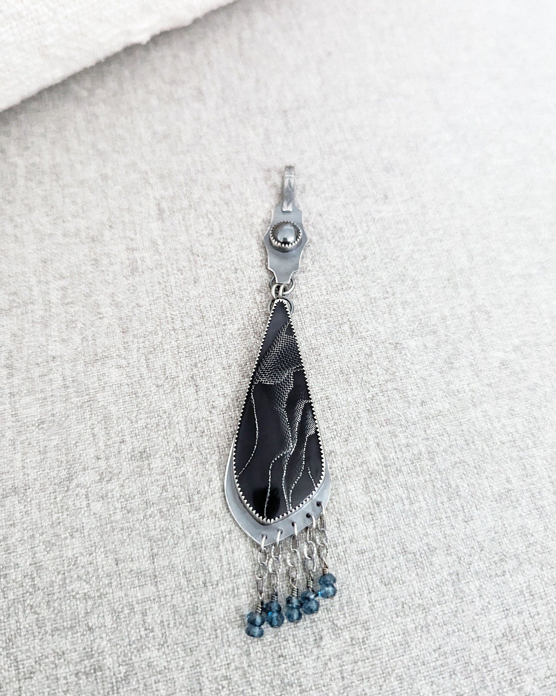 Close up of web patterned resin cabochon in sterling silver setting