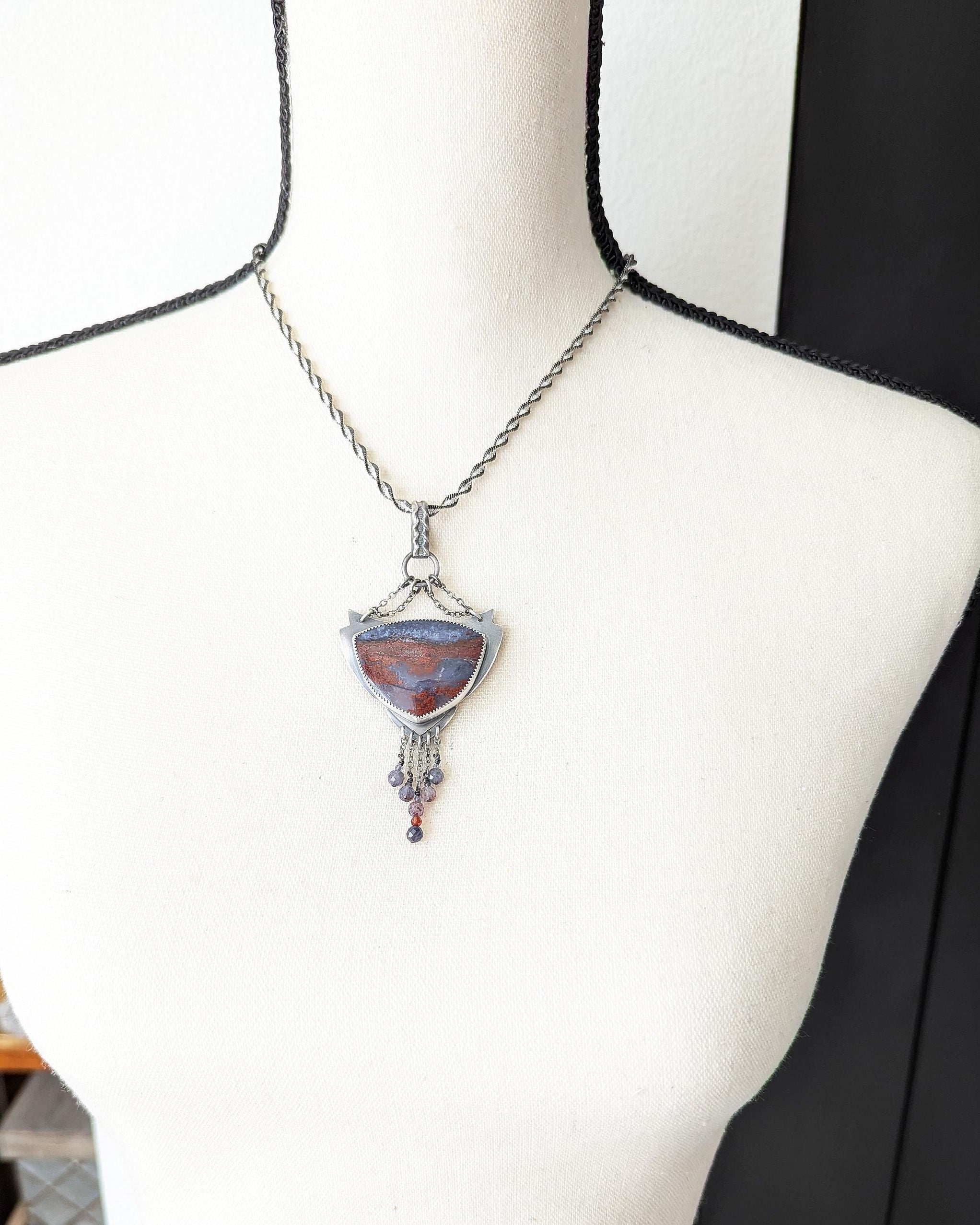 Moody romantic statement pendant with deep red and purple tones on bust for scale