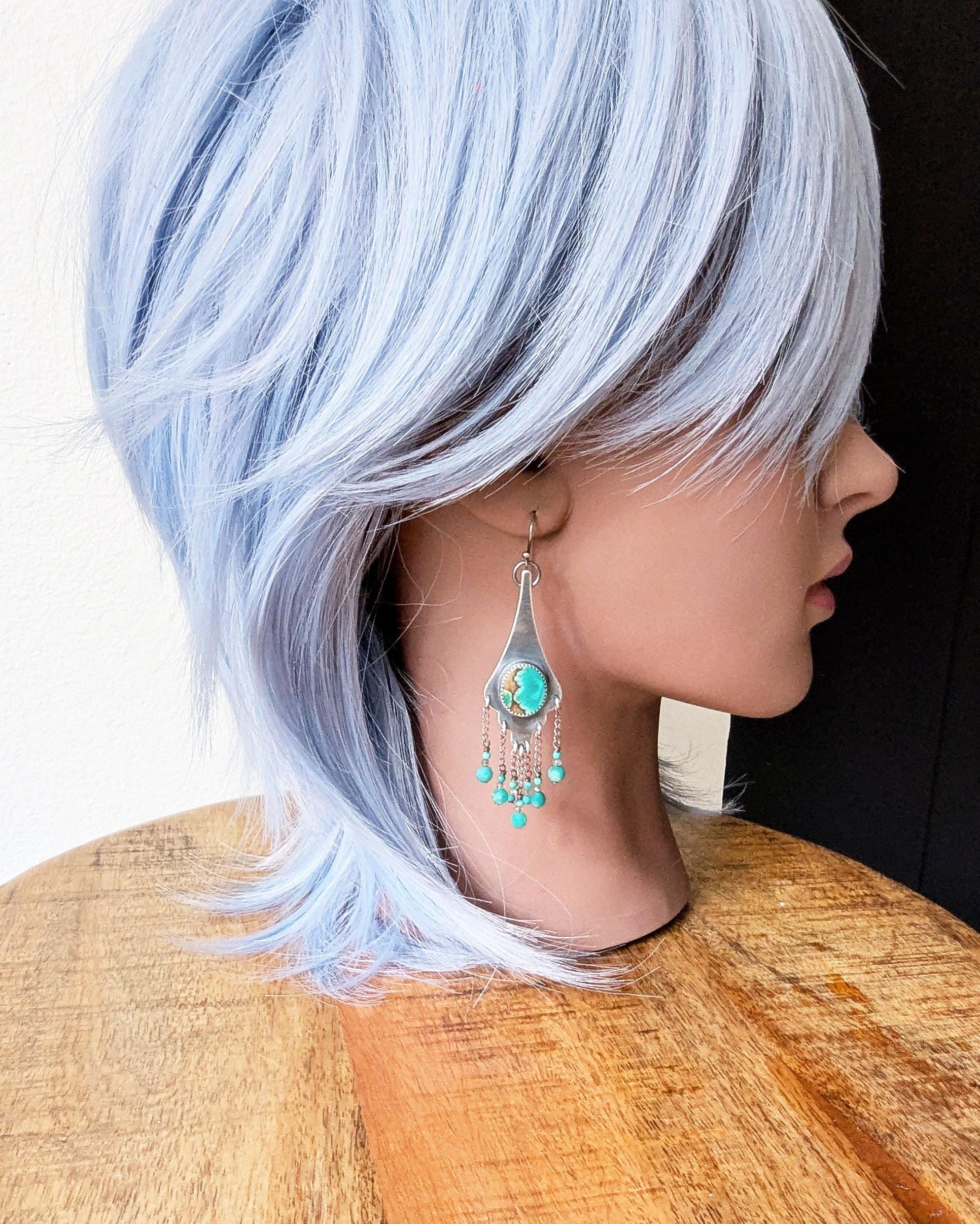 Statement earrings with green-blue turquoise and layered chain movement on mannequin for scale
