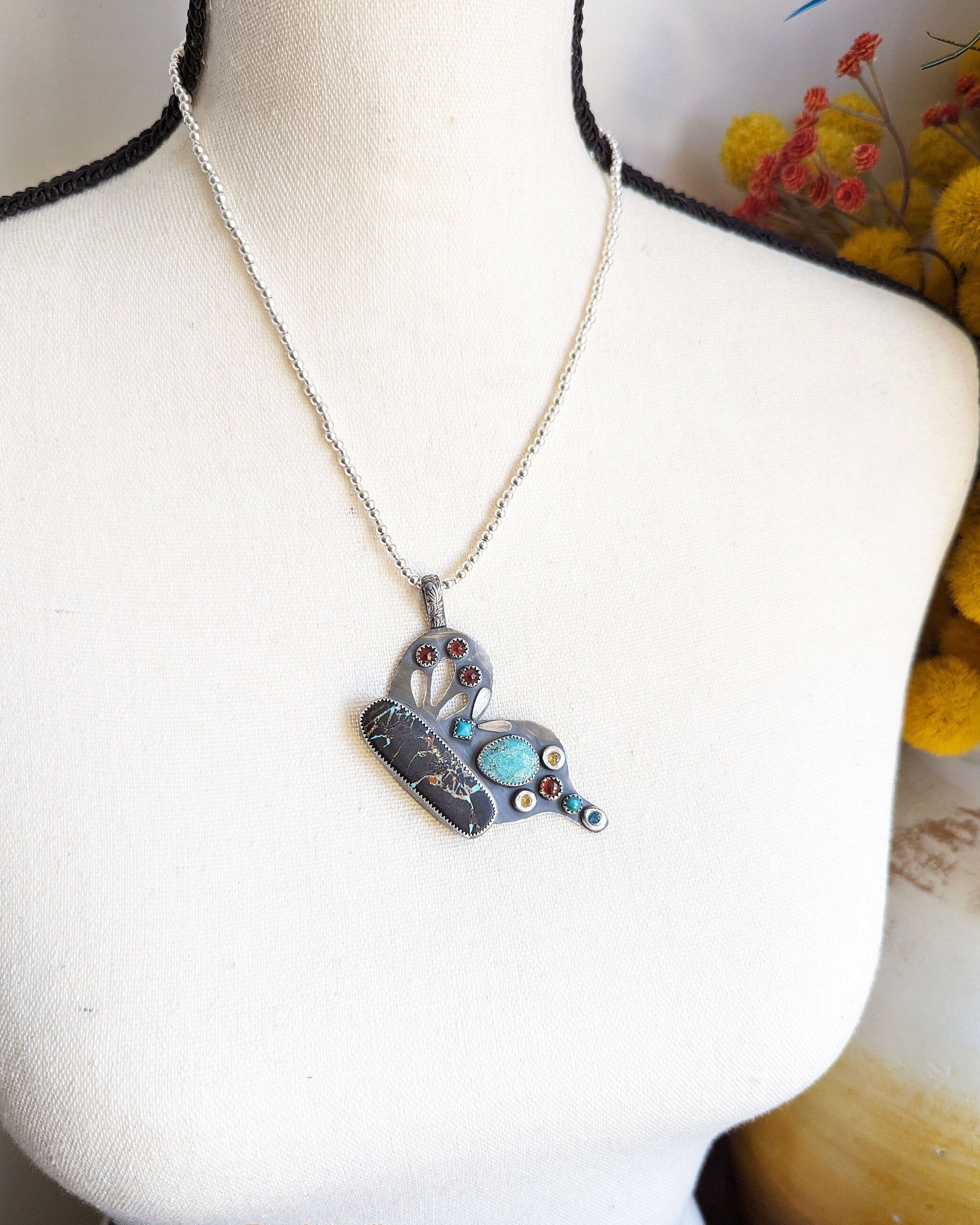 Butterfly pendant worn on silver chain for scale on bust.
