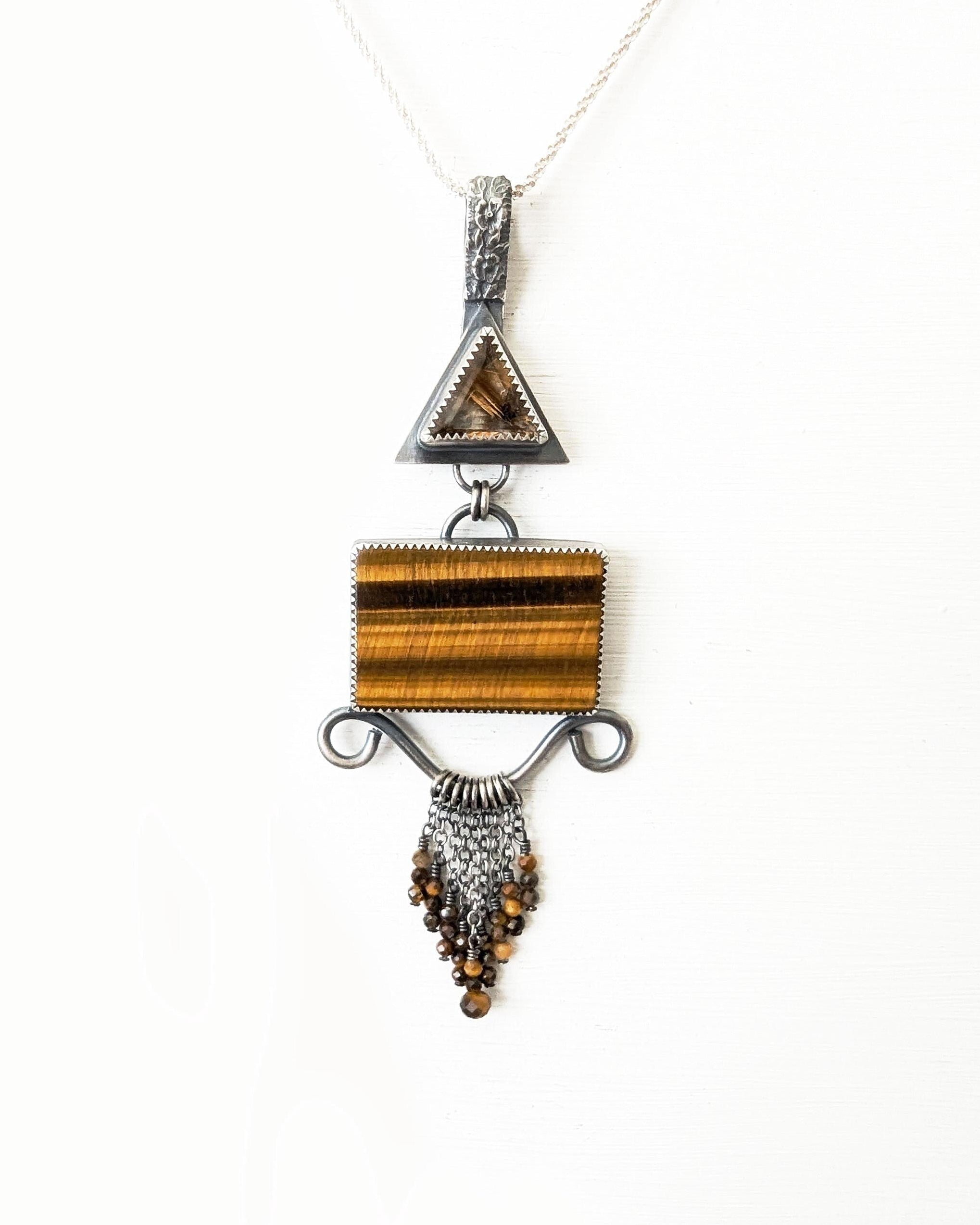 Close up of star rutile quartz crystal with golden rutile burst shown on chain (not included)