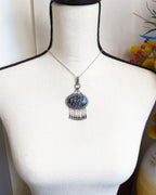 Snowflake obsidian pendant worn on a bust to show pendant size
