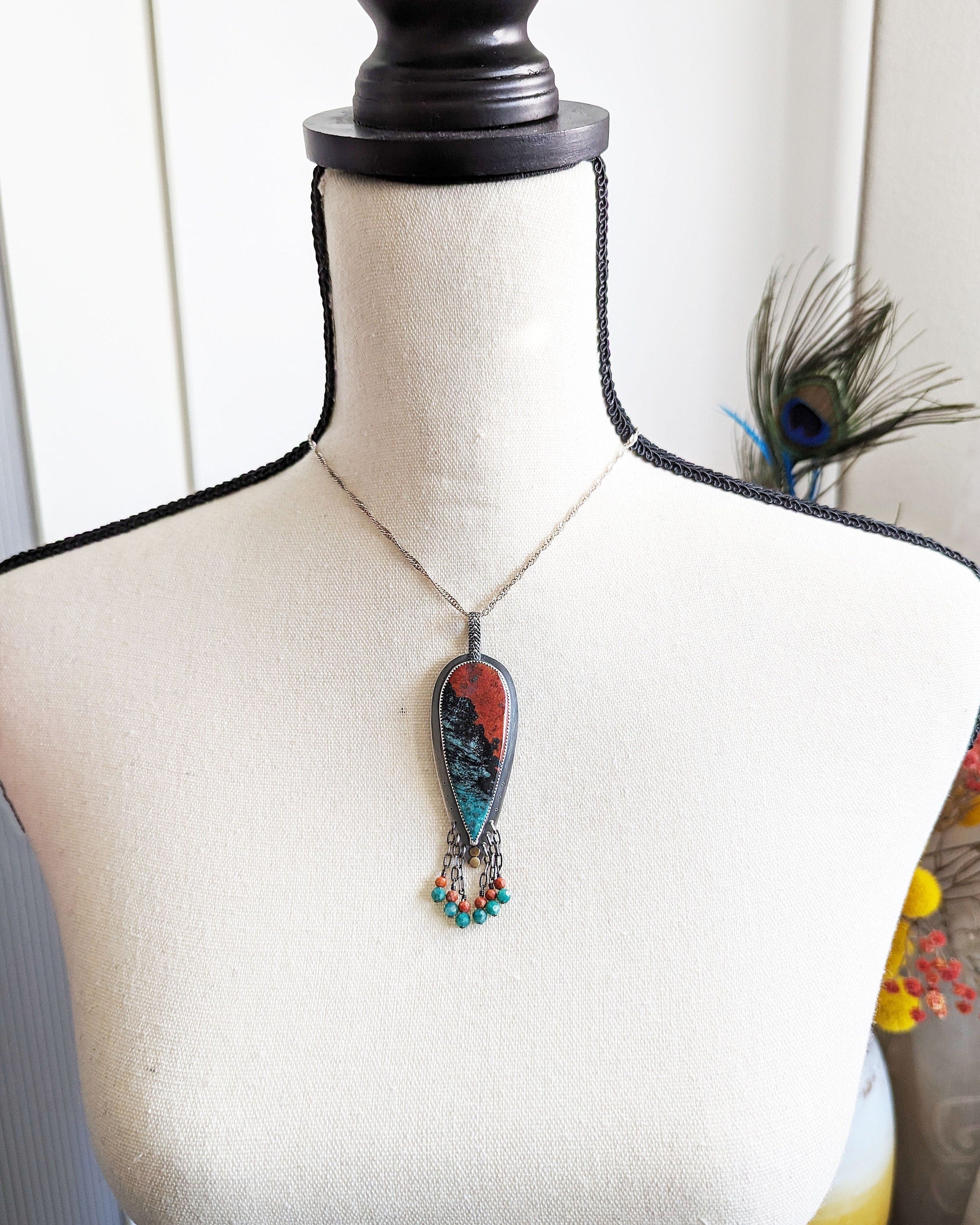 Sonoran jasper pendant worn on chain to show length and teardrop shape
