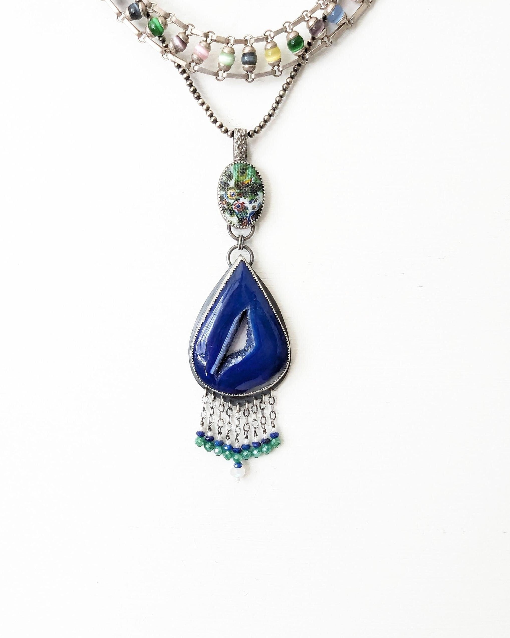 Large blue agate pendant with druzy window and gemstone fringe shown on chain with layering necklaces for styling