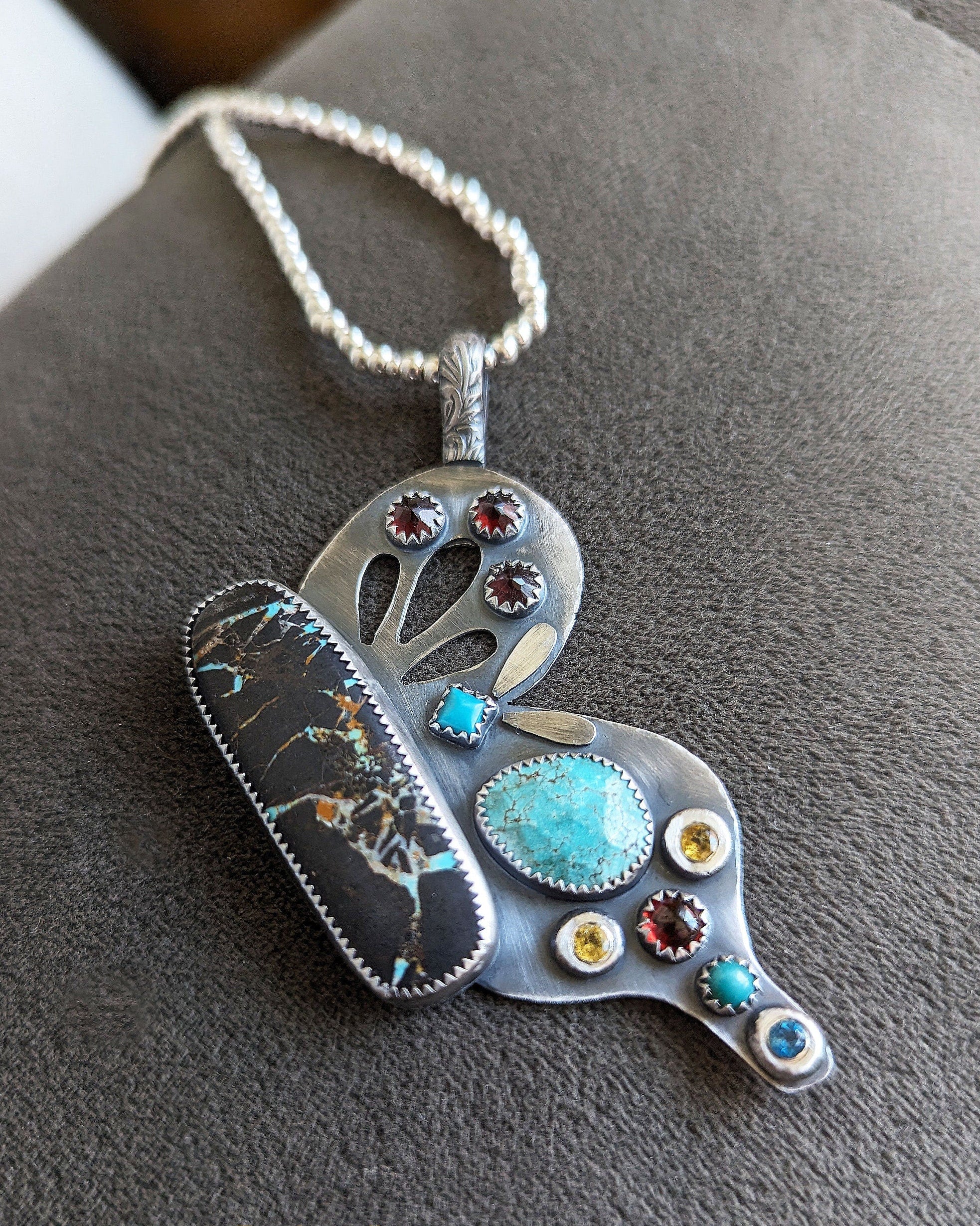 Decorative butterfly wing pendant with colorful gemstones in oxidized sterling silver