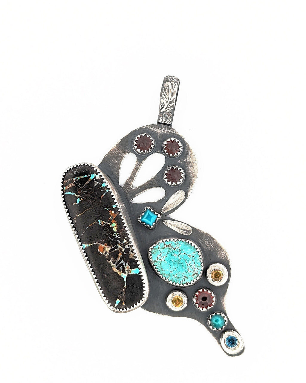 Hand-pierced wing details on sterling silver butterfly pendant in bright white light.
