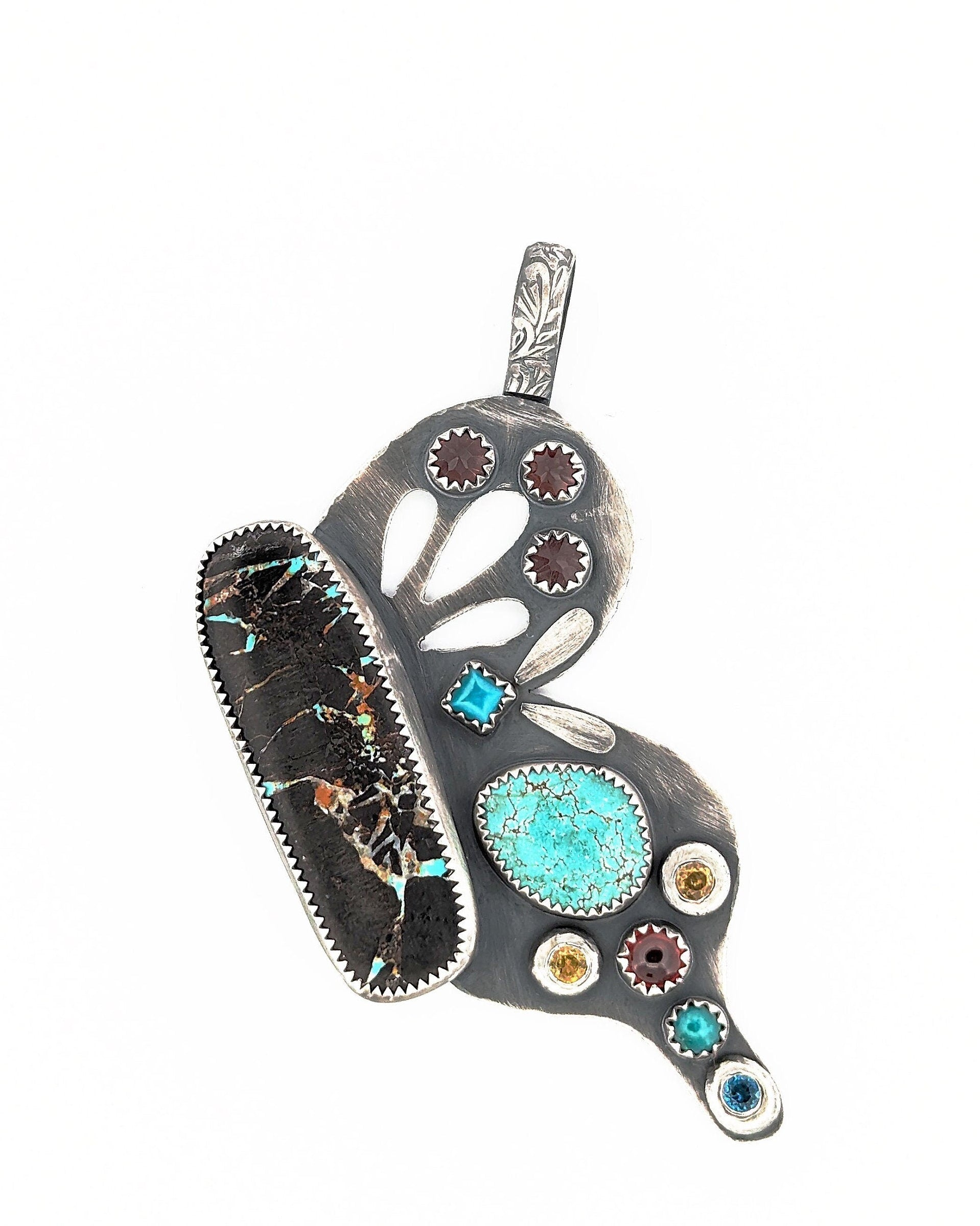 Hand-pierced wing details on sterling silver butterfly pendant in bright white light.
