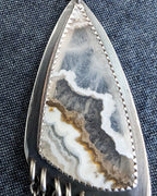 Close up of white lace agate stone in artisan pendant