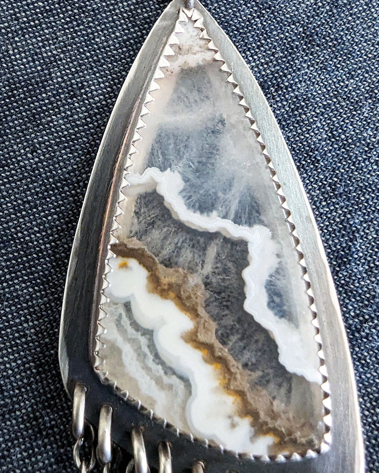 Close up of white lace agate stone in artisan pendant