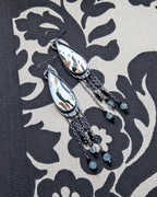 Close-up of reclaimed aqua glass with copper and black accents in silver earrings
