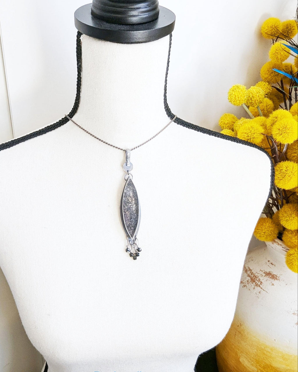 Handcrafted black rutile quartz pendant by Rebellenhaus on bust for scale
