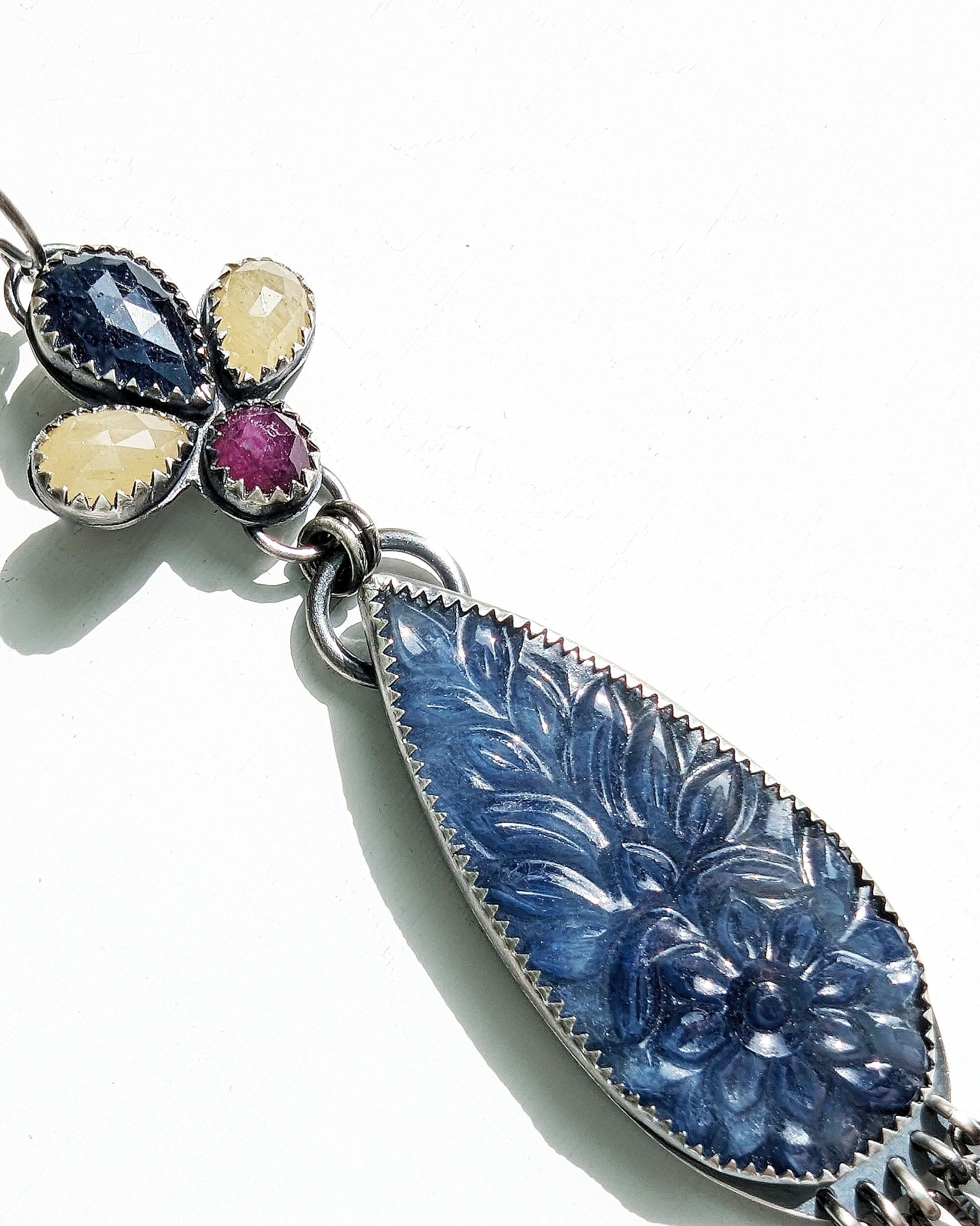 Close up of multi- colored sapphires in artisan earrings