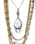 Pear shaped carved mother of pearl pendant in oxidized sterling silver and brass