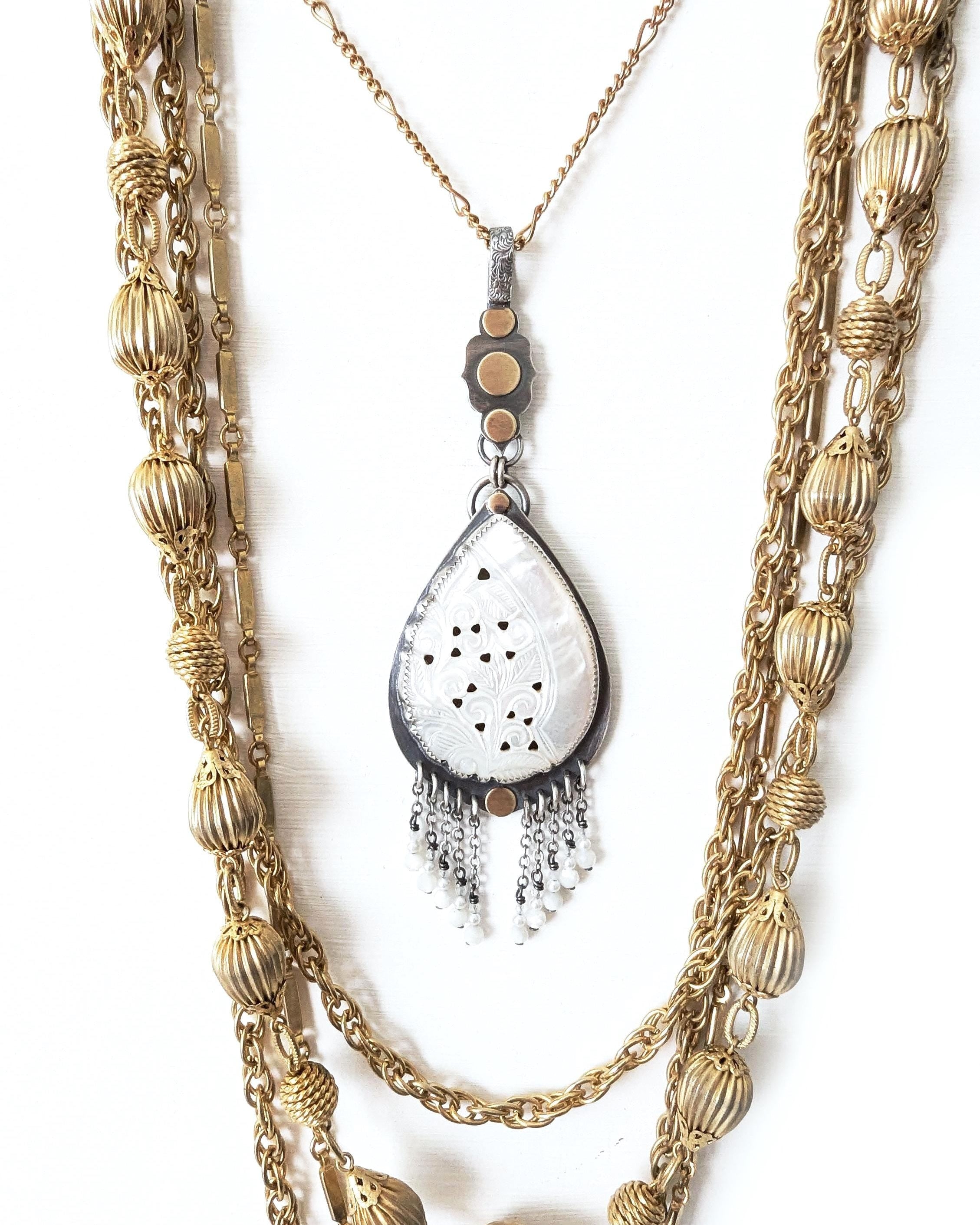 Pear shaped carved mother of pearl pendant in oxidized sterling silver and brass
