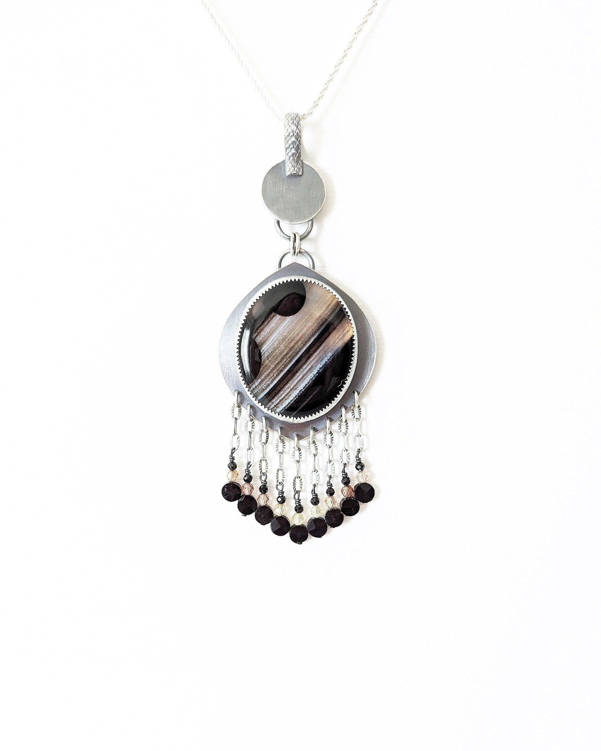 Cosmic-inspired black agate jewelry with artisan silver and beaded accents shown on chain (not included)