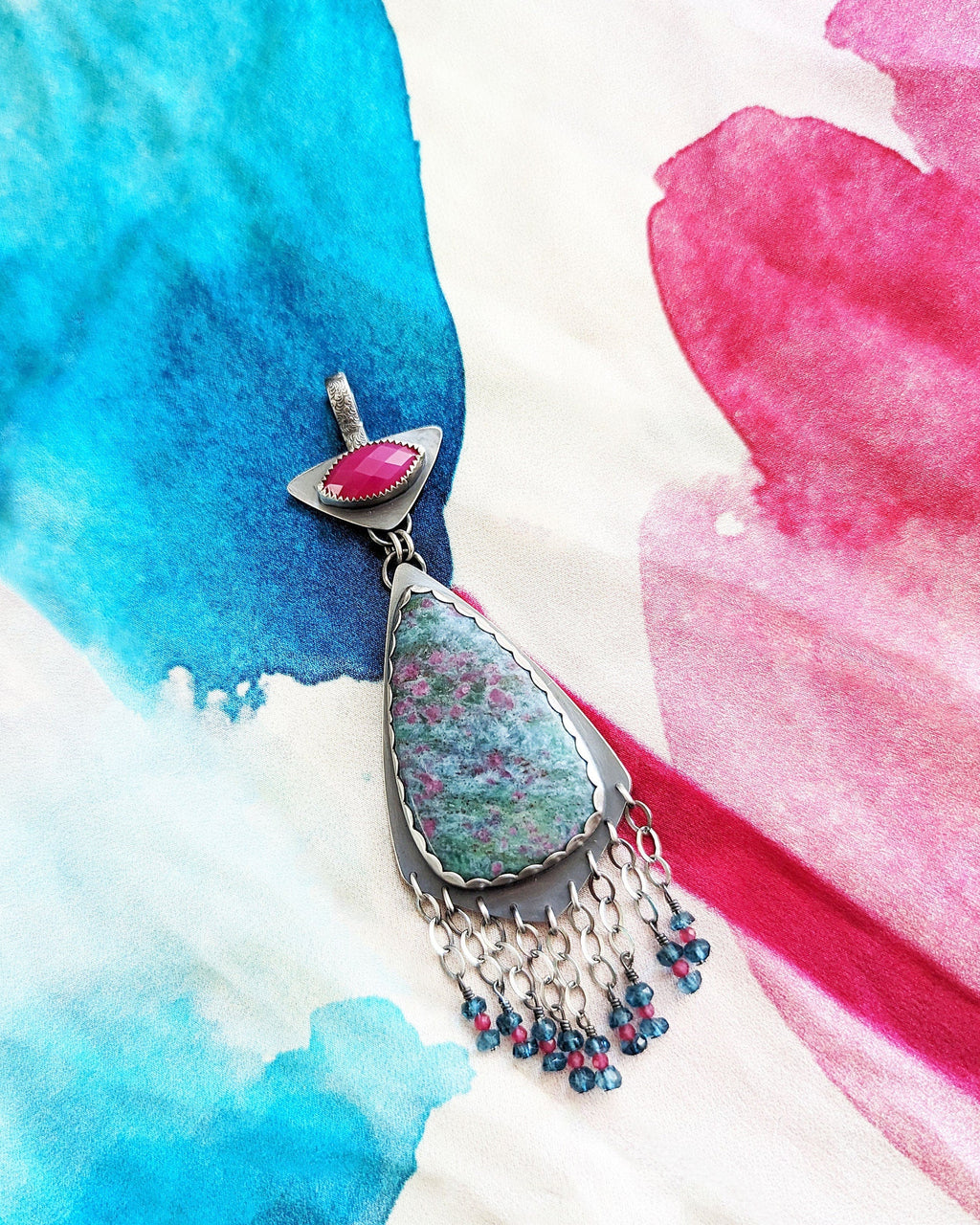 Bold gemstone pendant featuring ruby in kyanite with blue topaz fringe