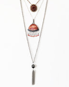 Statement orange agate pendant with square link fringe and coral accents layered with necklaces for styling
