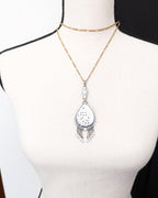Handcrafted statement necklace with luminous carved shell centerpiece shown on bust for size