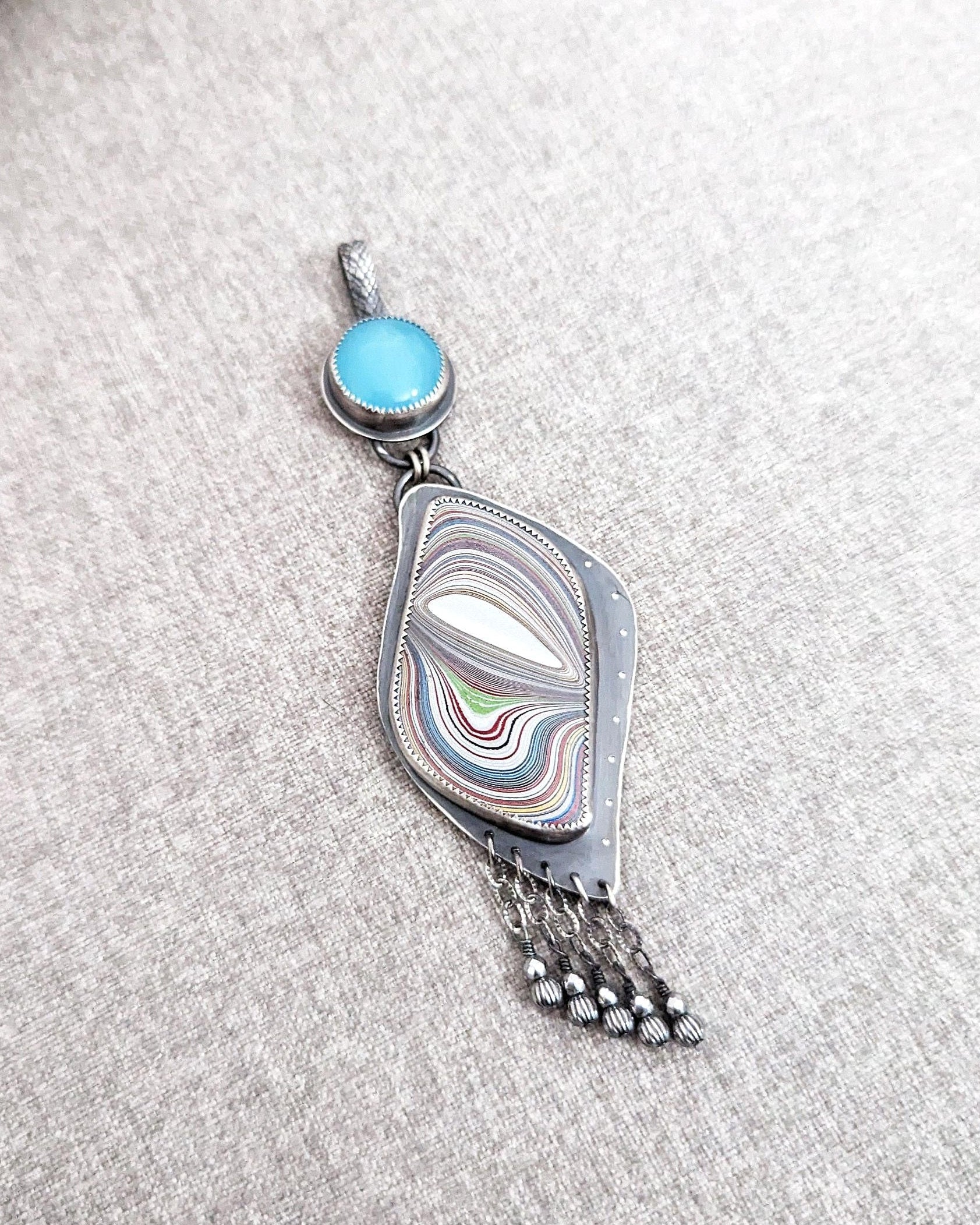 Collector gemstone pendant with layered blue and silver shimmer