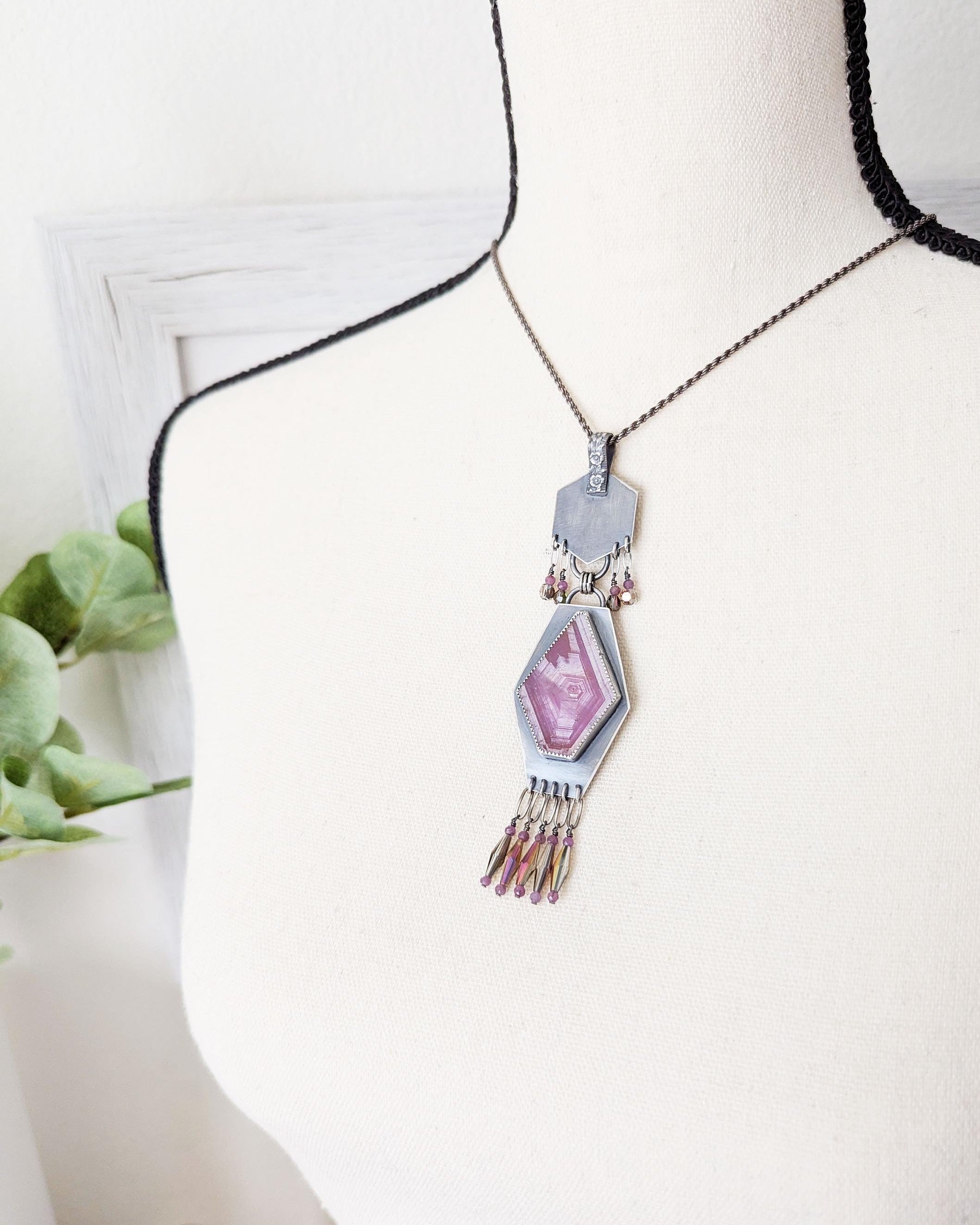 Bold fuchsia gemstone statement pendant with gold flash accents shown on bust for scale