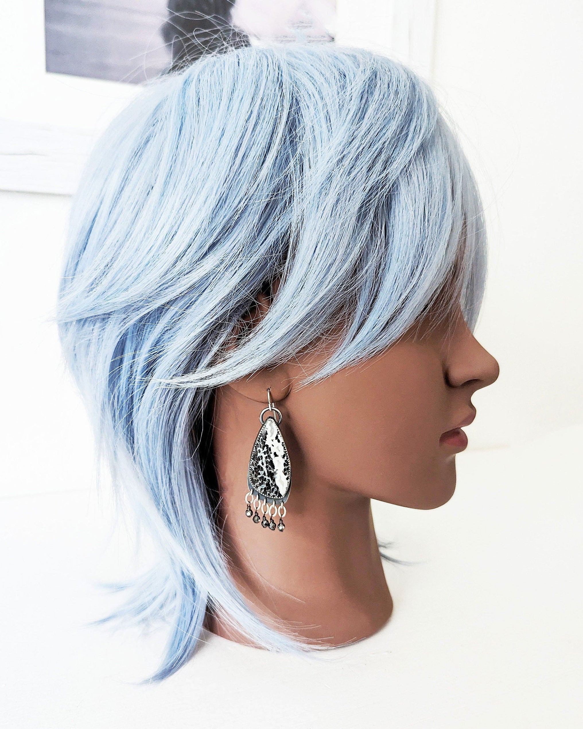 One of a kind black and white palm root agate earrings by Rebellenhaus on mannequin for scale