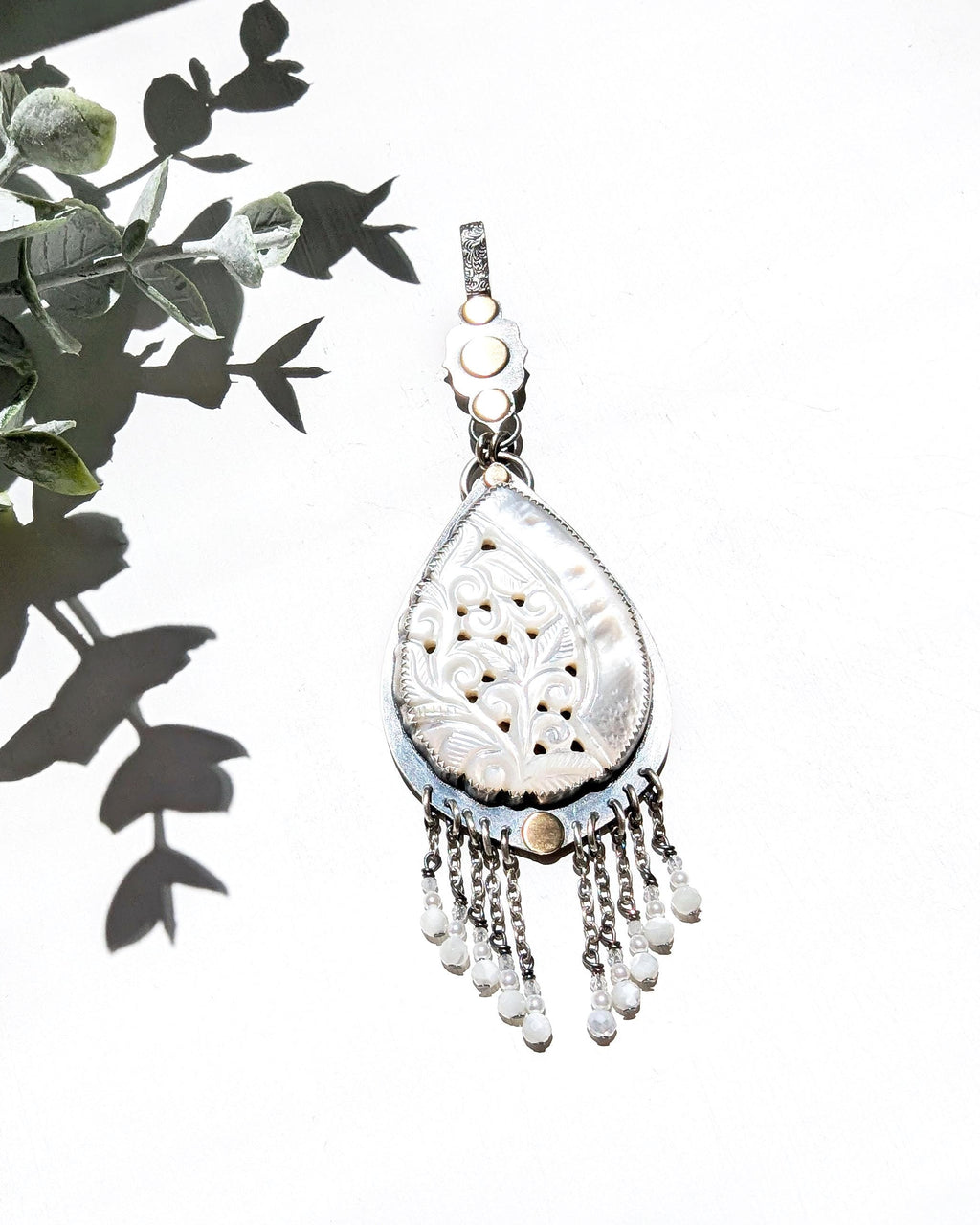 Romantic coastal pendant featuring carved mother of pearl and delicate beaded accents