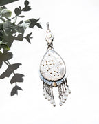 Romantic coastal pendant featuring carved mother of pearl and delicate beaded accents