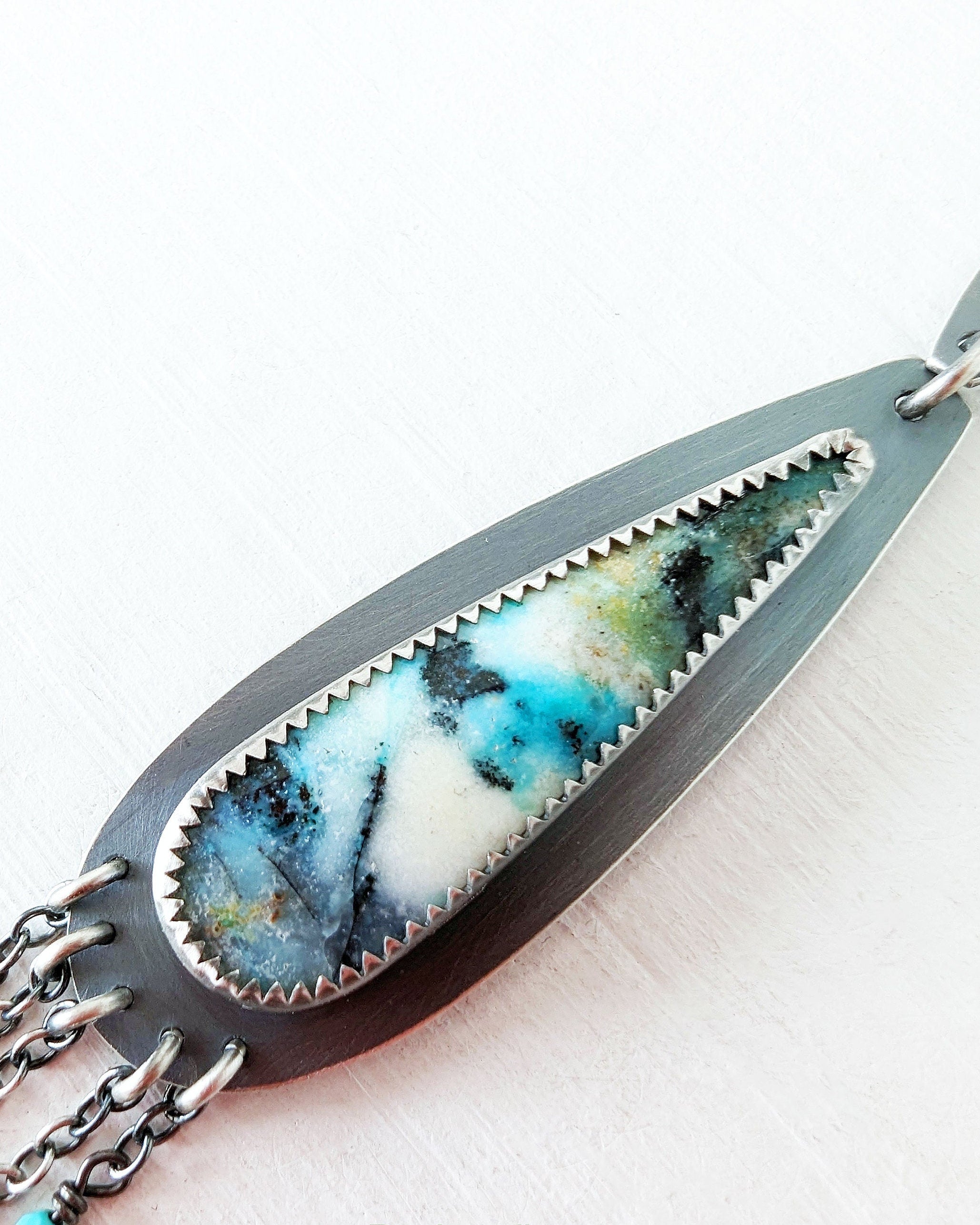 Necklace with marbled stone and chain design on a white background